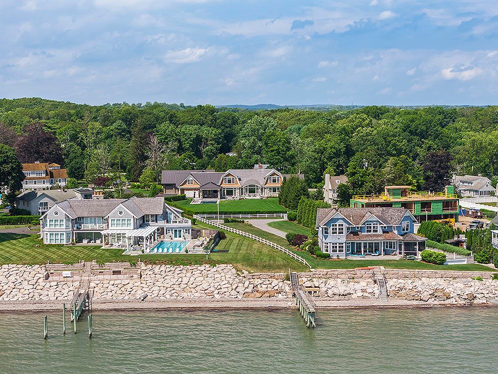 Coastal homes with docks and greenery on the shore.