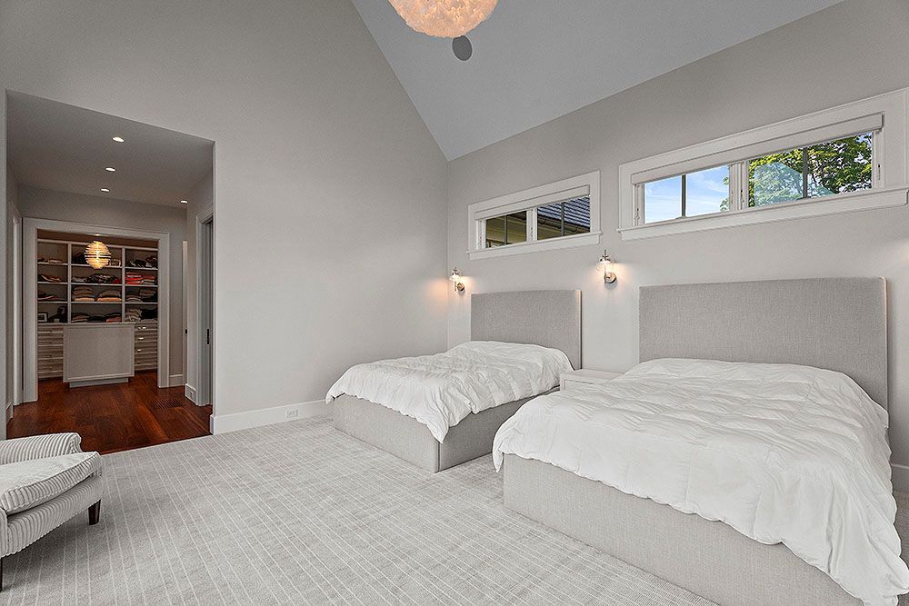 A bedroom with two twin beds, a walk-in closet, and a gray and white color scheme.