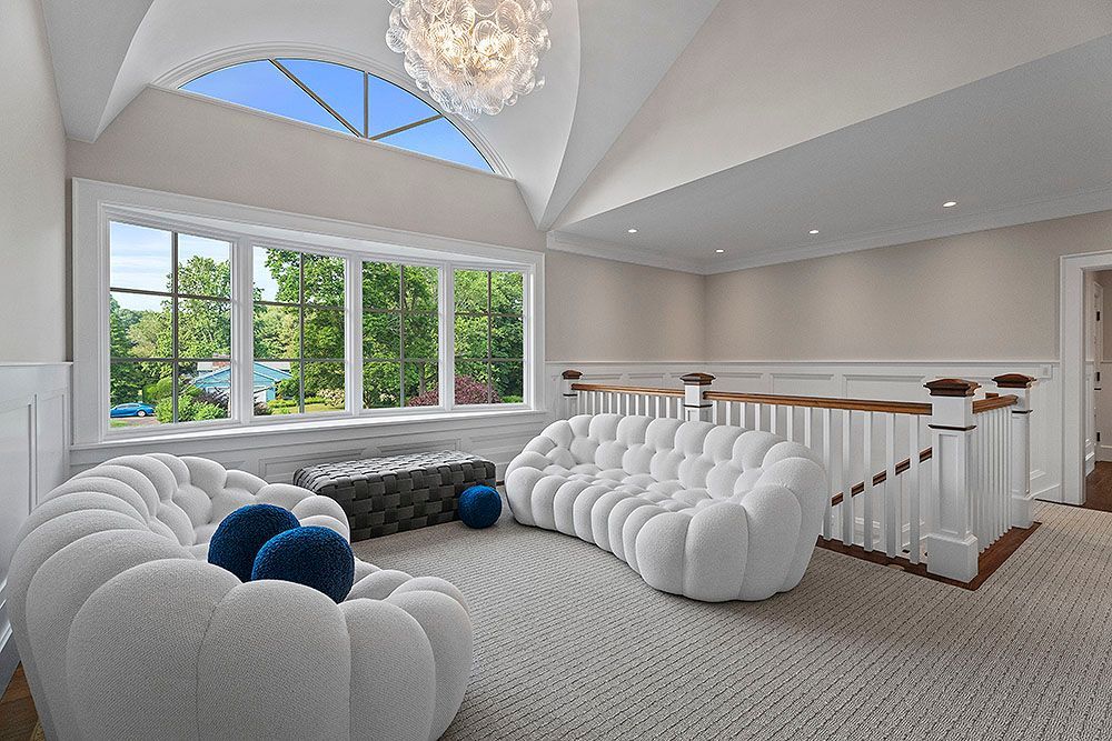 Bright, airy room with white bubble sofas, large windows, and a decorative chandelier.