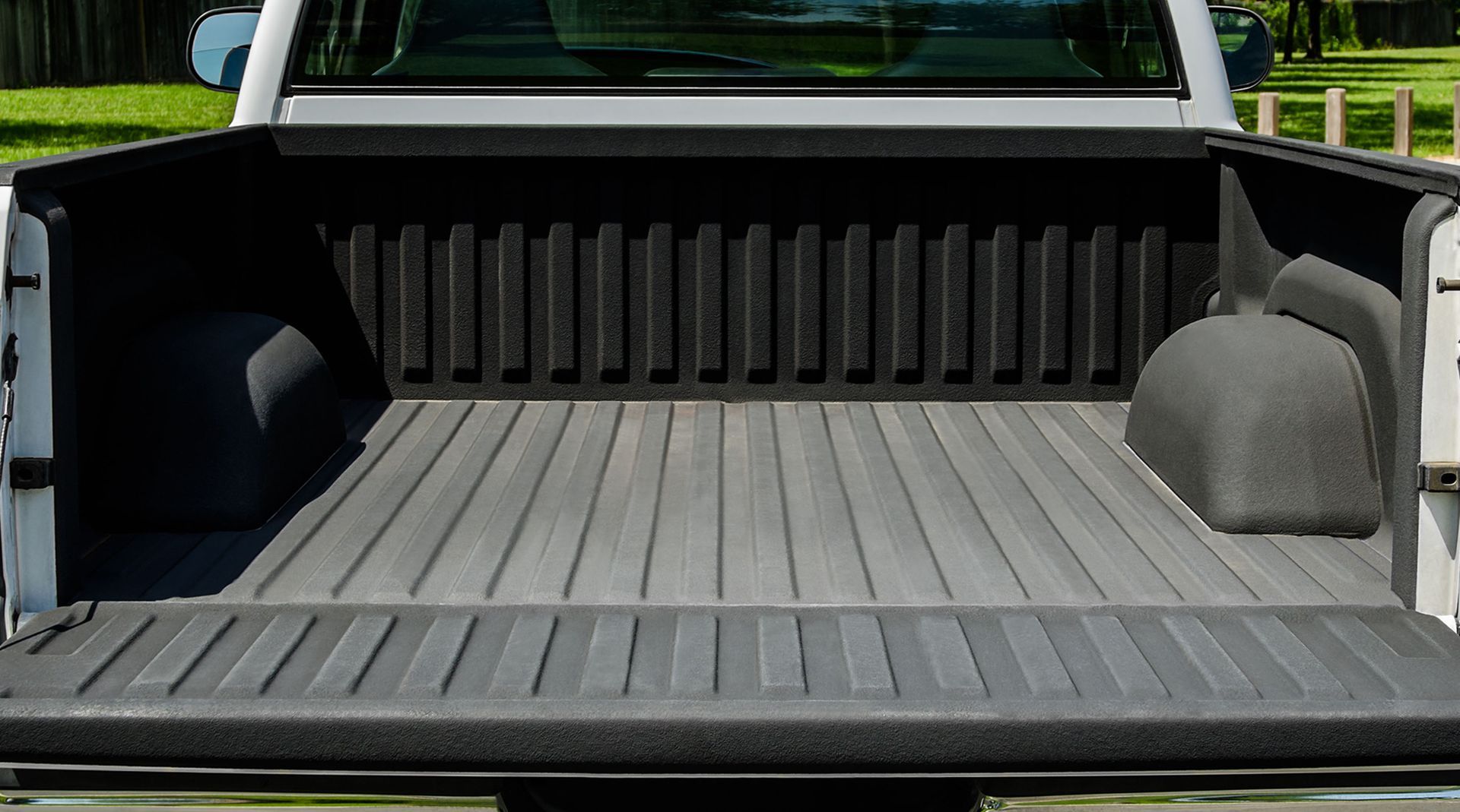 Empty silver truck bed with a black liner.