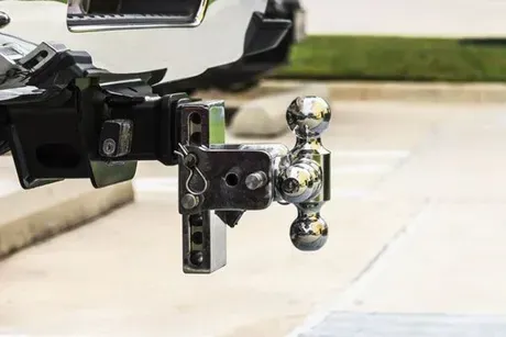 Close-up of a truck hitch with two chrome tow balls connected to a vehicle.