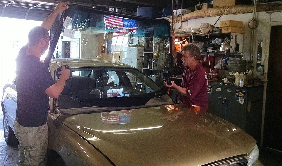 Two men are working on a car in a garage