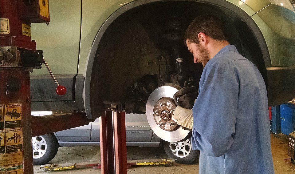 A man in a blue shirt is working on a car