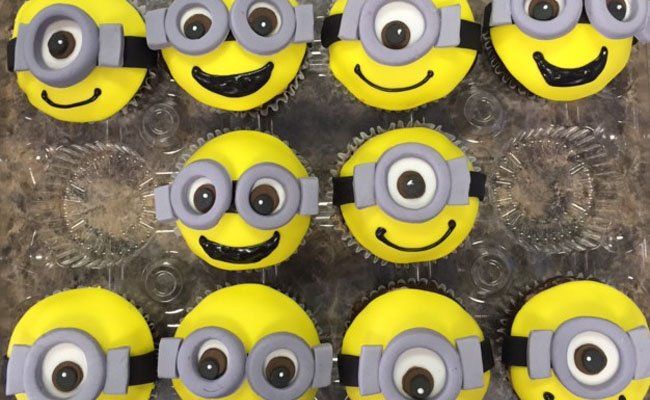 A bunch of cupcakes with minions on them