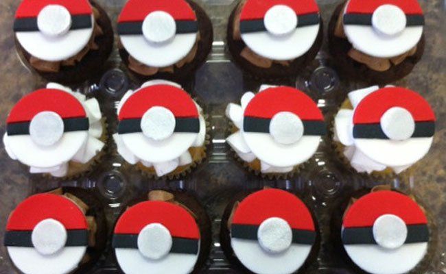 A bunch of cupcakes with pokeballs on them