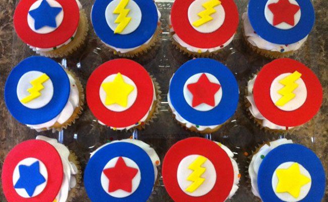 A bunch of cupcakes with superhero symbols on them