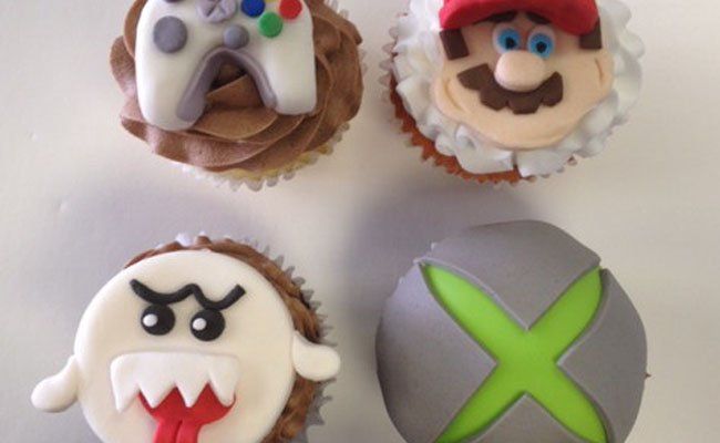 A group of cupcakes decorated with video game characters including mario and xbox