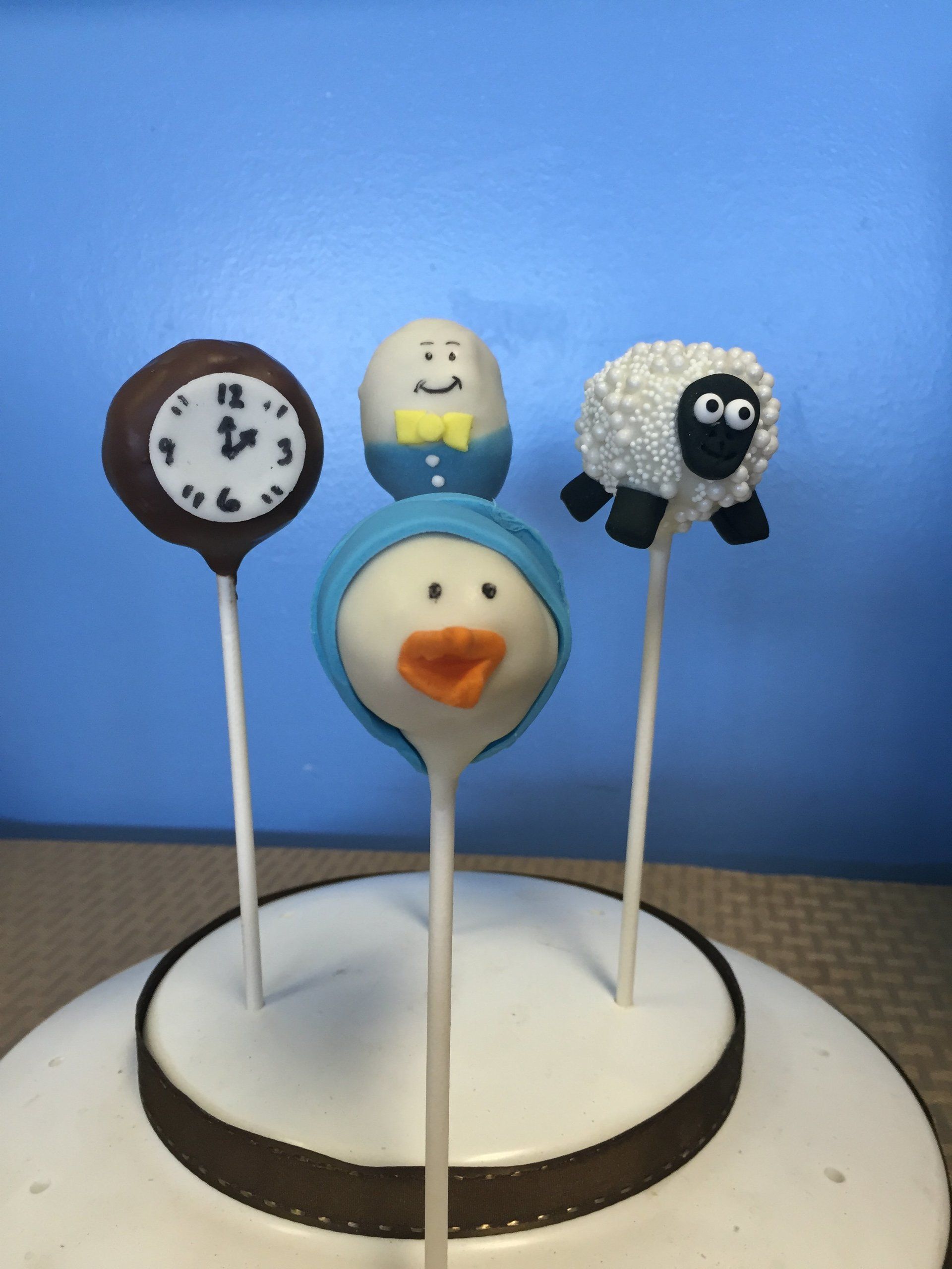 A cake with a clock a duck and a sheep on it