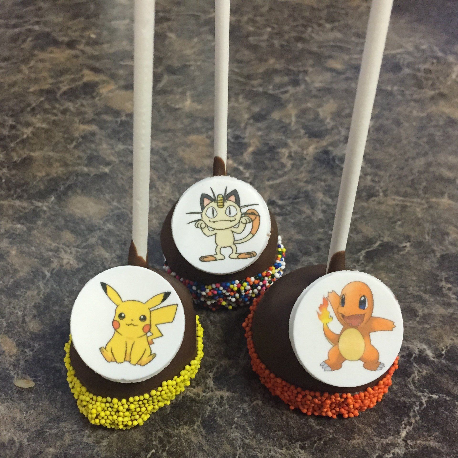 Three pokemon cake pops are sitting on a table