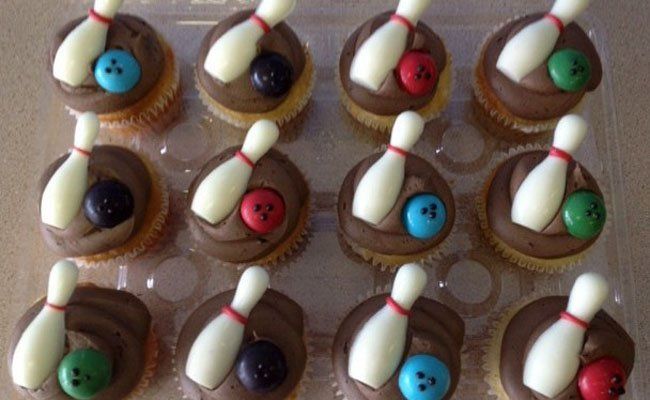 A tray of bowling cupcakes decorated with bowling pins and bowling balls.