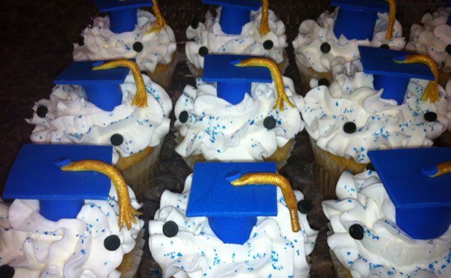 A bunch of cupcakes with graduation caps on them