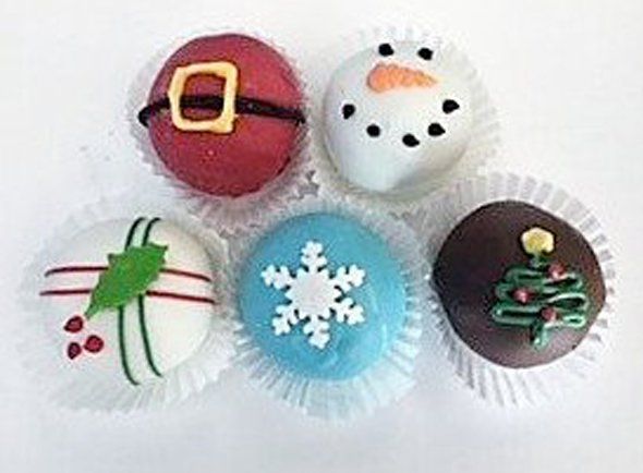 A group of cupcakes decorated for christmas are sitting on top of each other on a table.