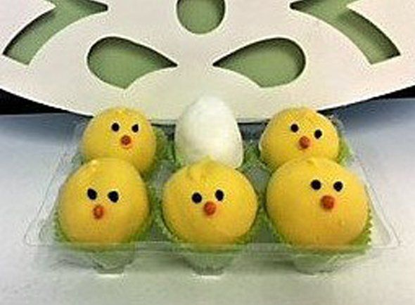A plastic tray filled with yellow chicks and an egg.