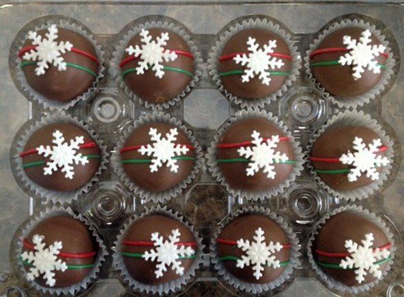 A tray of chocolate cupcakes with snowflakes on them