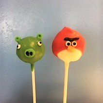 Two angry bird cake pops are sitting next to each other on a table.