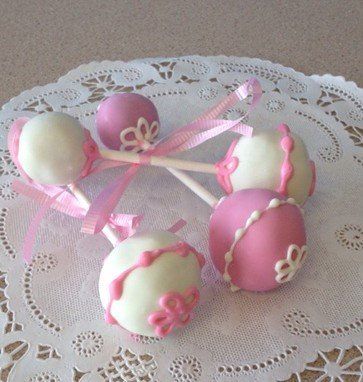 Pink and white cake pops on a lace napkin
