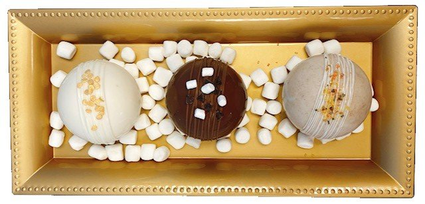 Three chocolate balls with marshmallows in a gold box
