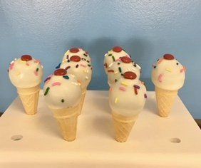 A bunch of ice cream cones with sprinkles on them
