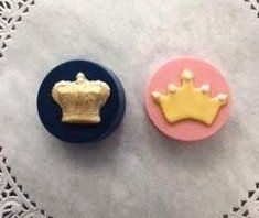 Two cupcakes with crowns on them are sitting on a table.