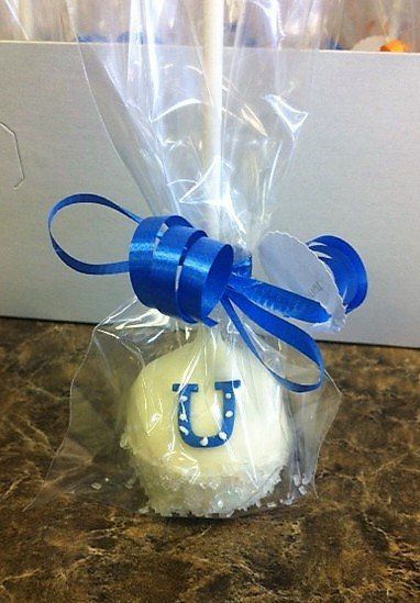 A white cake pop with a blue horseshoe on it