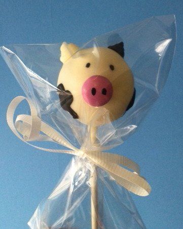 A cake pop in the shape of a pig with a pink nose