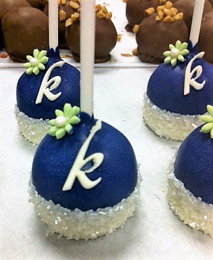 Blue cake pops with the letter k on them