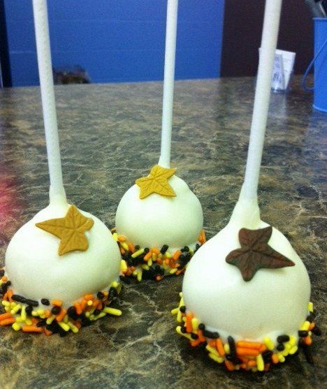 Three cake pops with stars on them are on a table