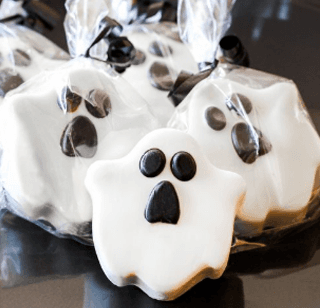 A bunch of ghost cookies in plastic bags on a table