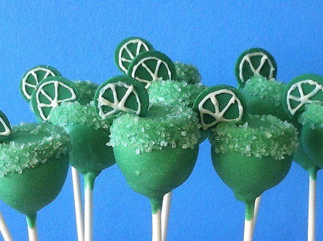 A bunch of green cake pops with lemon slices on them