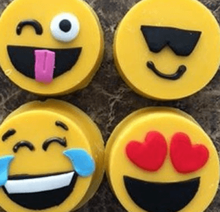 Four yellow circles with smiley faces on them are sitting on a table.