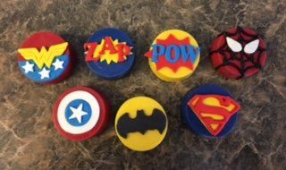 A group of superhero cupcakes are sitting on a table