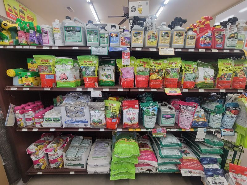 A grocery store shelf filled with lots of gardening products.