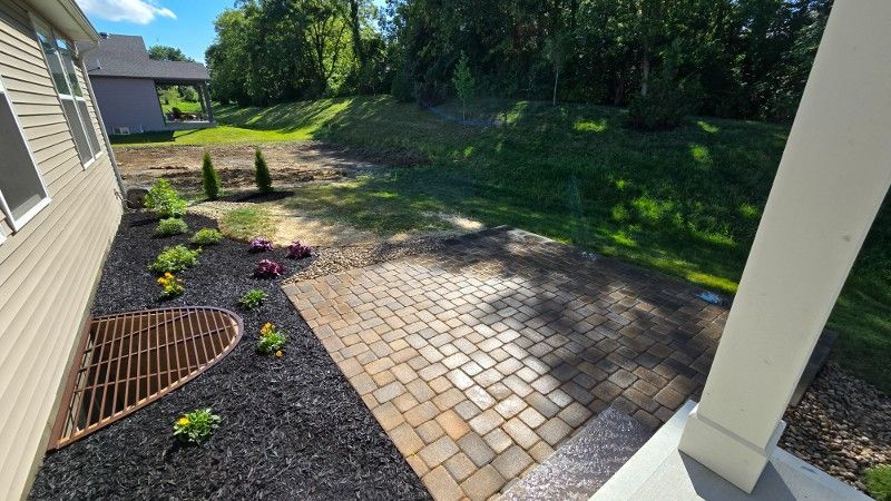 A house with a patio and a drain in the backyard.