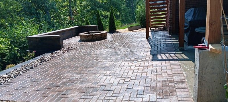 A brick walkway with a fire pit in the middle of it