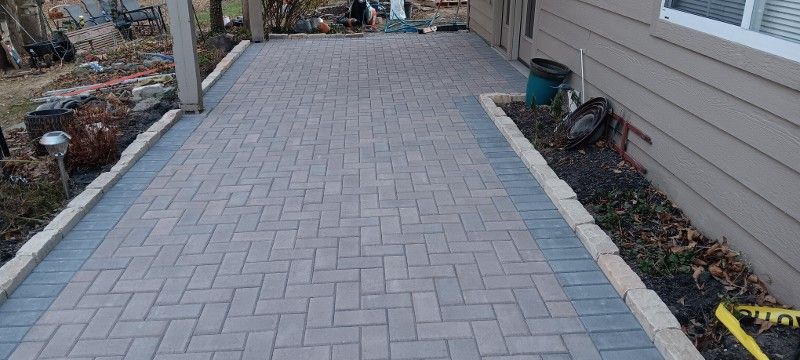 A brick walkway is being built in front of a house.
