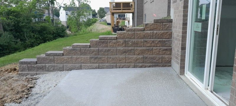 A brick wall is being built on the side of a house.