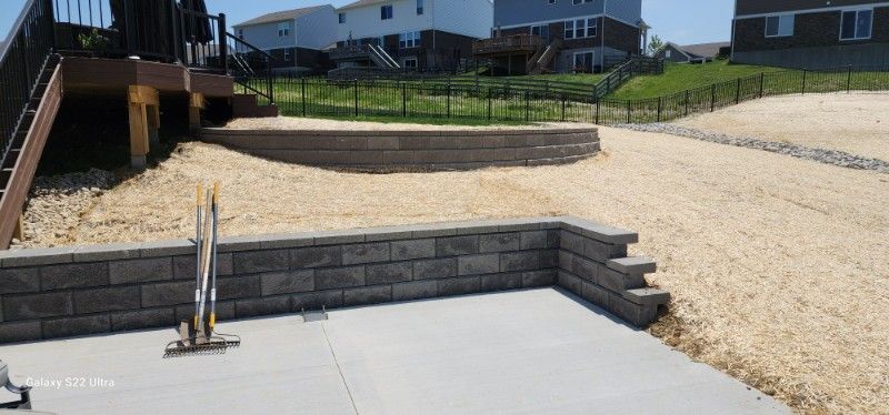 A brick wall is being built in the backyard of a house.