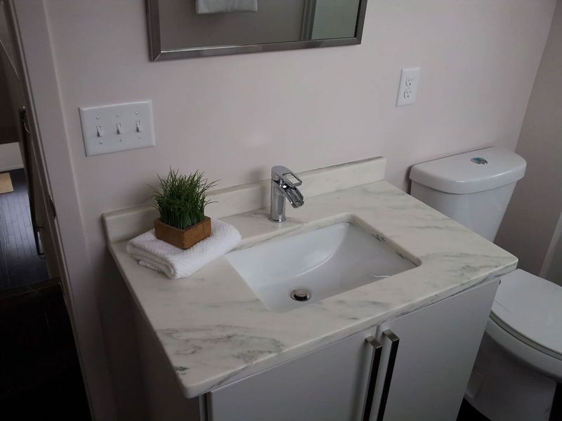 A bathroom with a sink , toilet and mirror.
