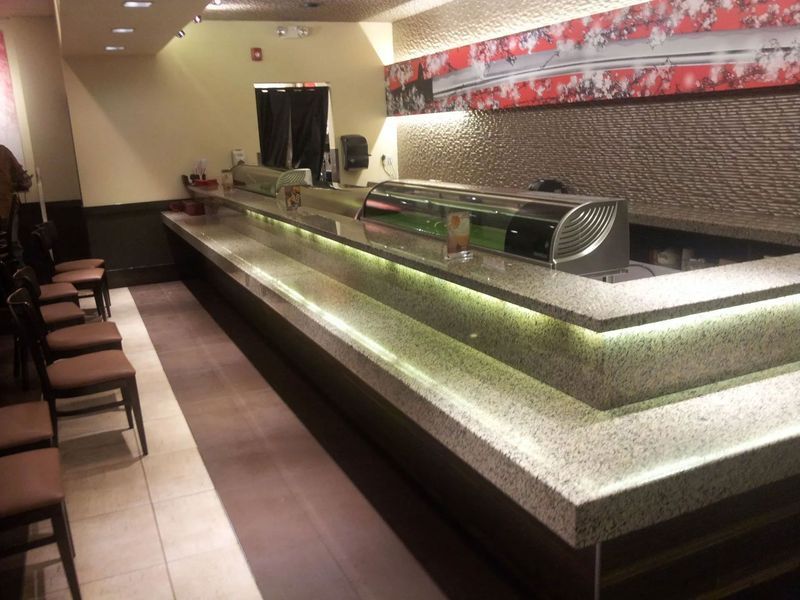 A restaurant with a long counter and chairs