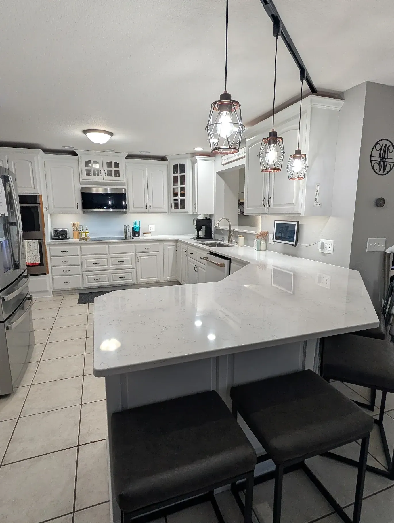 A kitchen with white cabinets and a large island in the middle