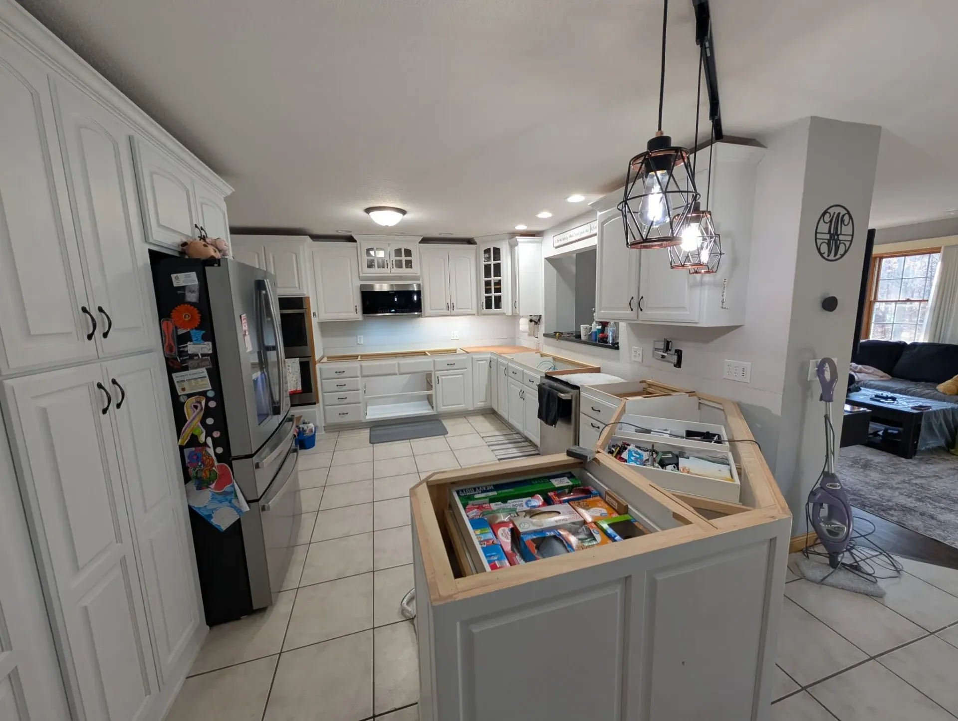 A kitchen with white cabinets and a large island in the middle.