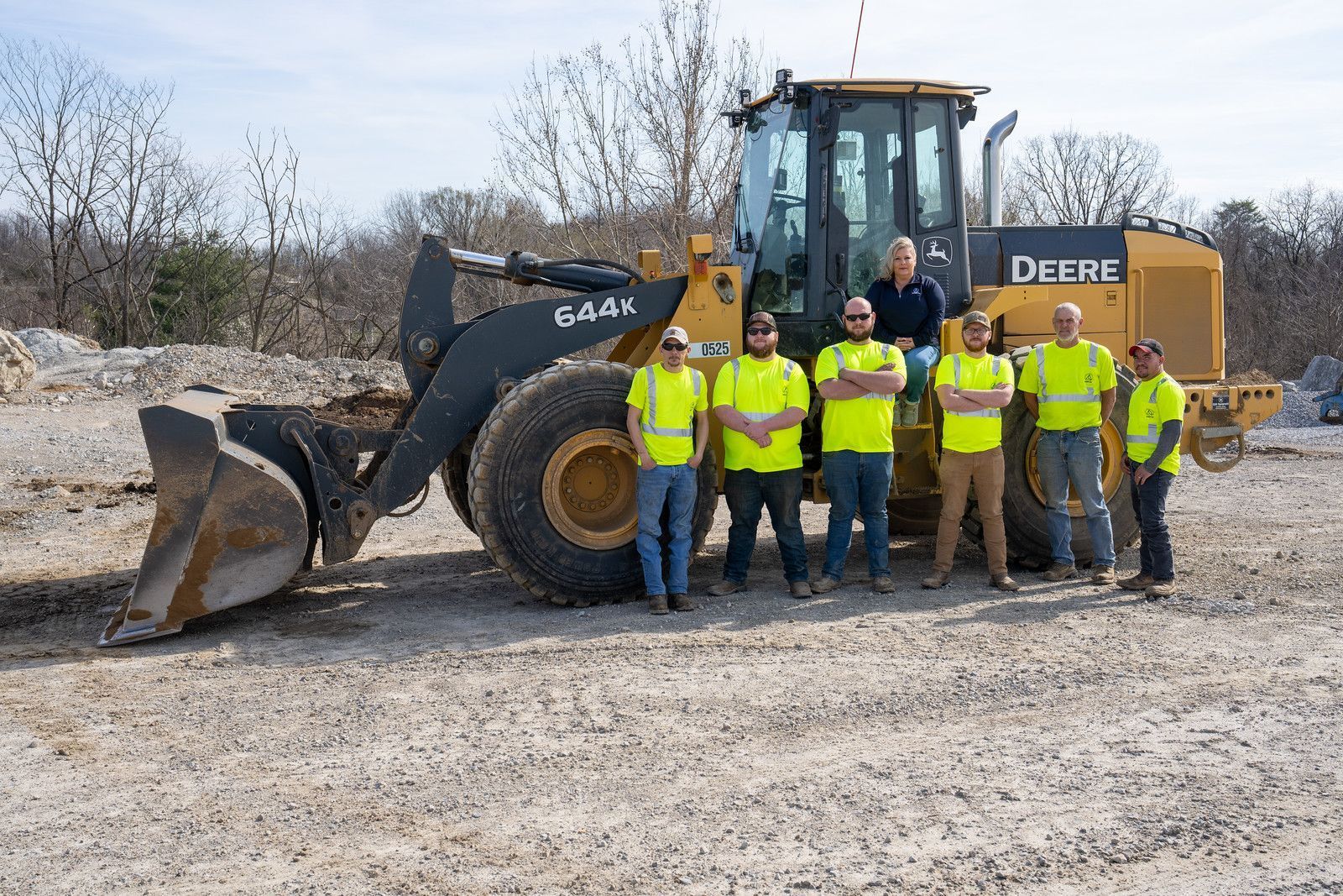 a group of construction workers standing next to a bulldozer