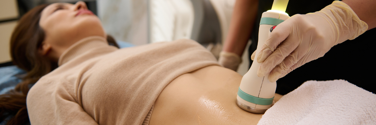 A person receiving an ultrasound on their abdomen, as a gloved hand holds the device to their skin.