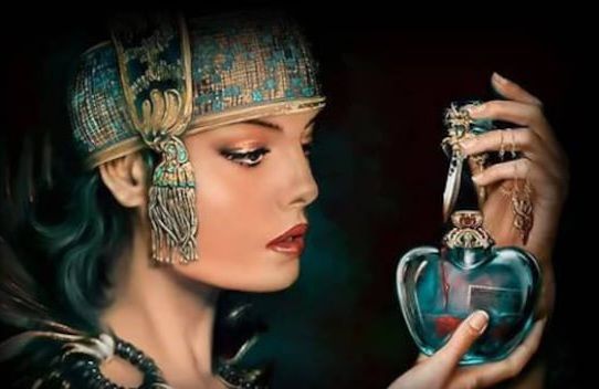 A woman with a teal headpiece and red lipstick gazes at a blue, heart-shaped bottle; dark background.