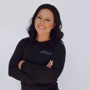 A woman wearing a black shirt with the word asics on it