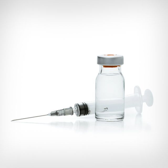 A bottle of vaccine and a syringe on a white background.