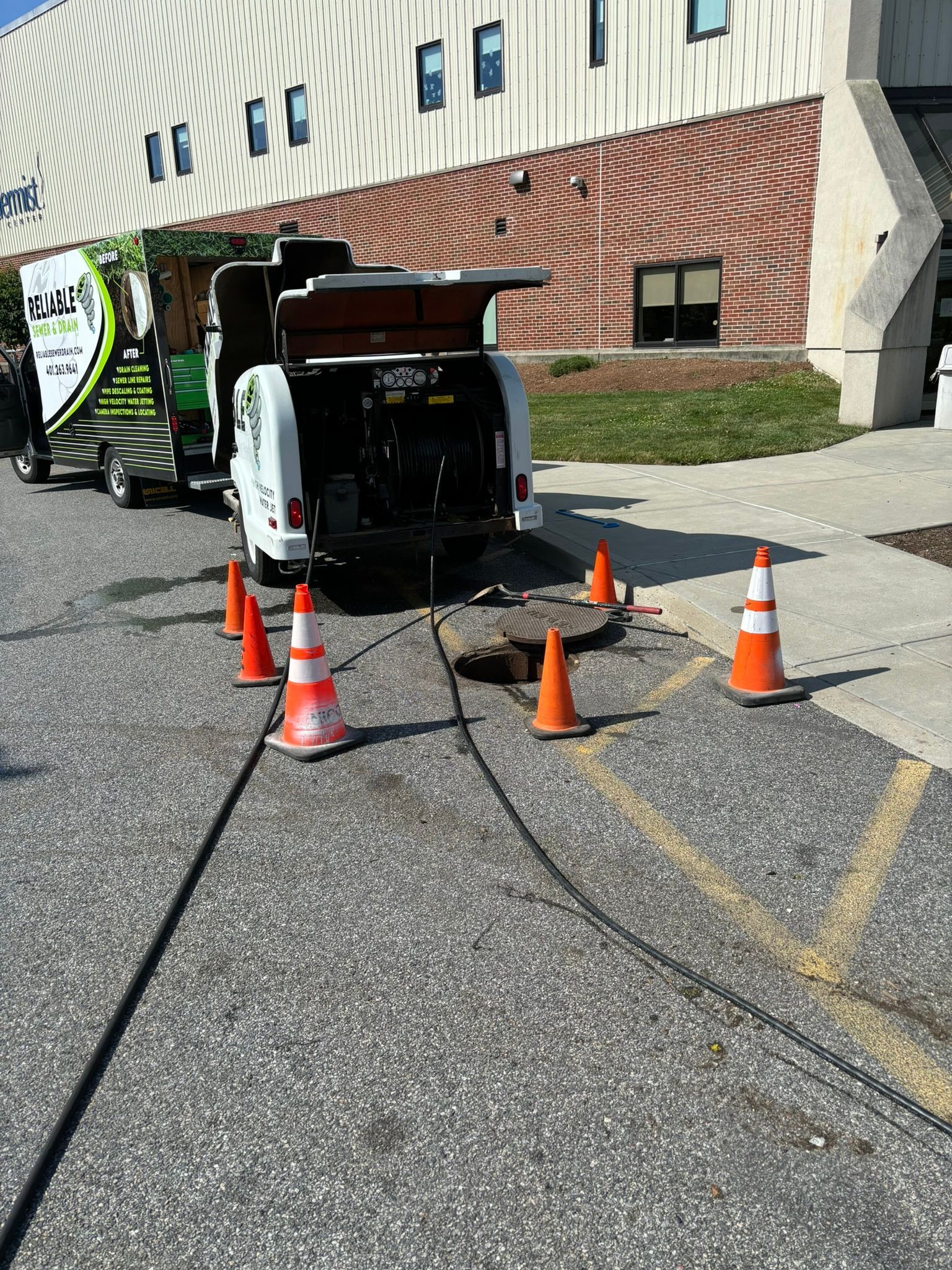A truck is sitting on the side of the road next to a building.