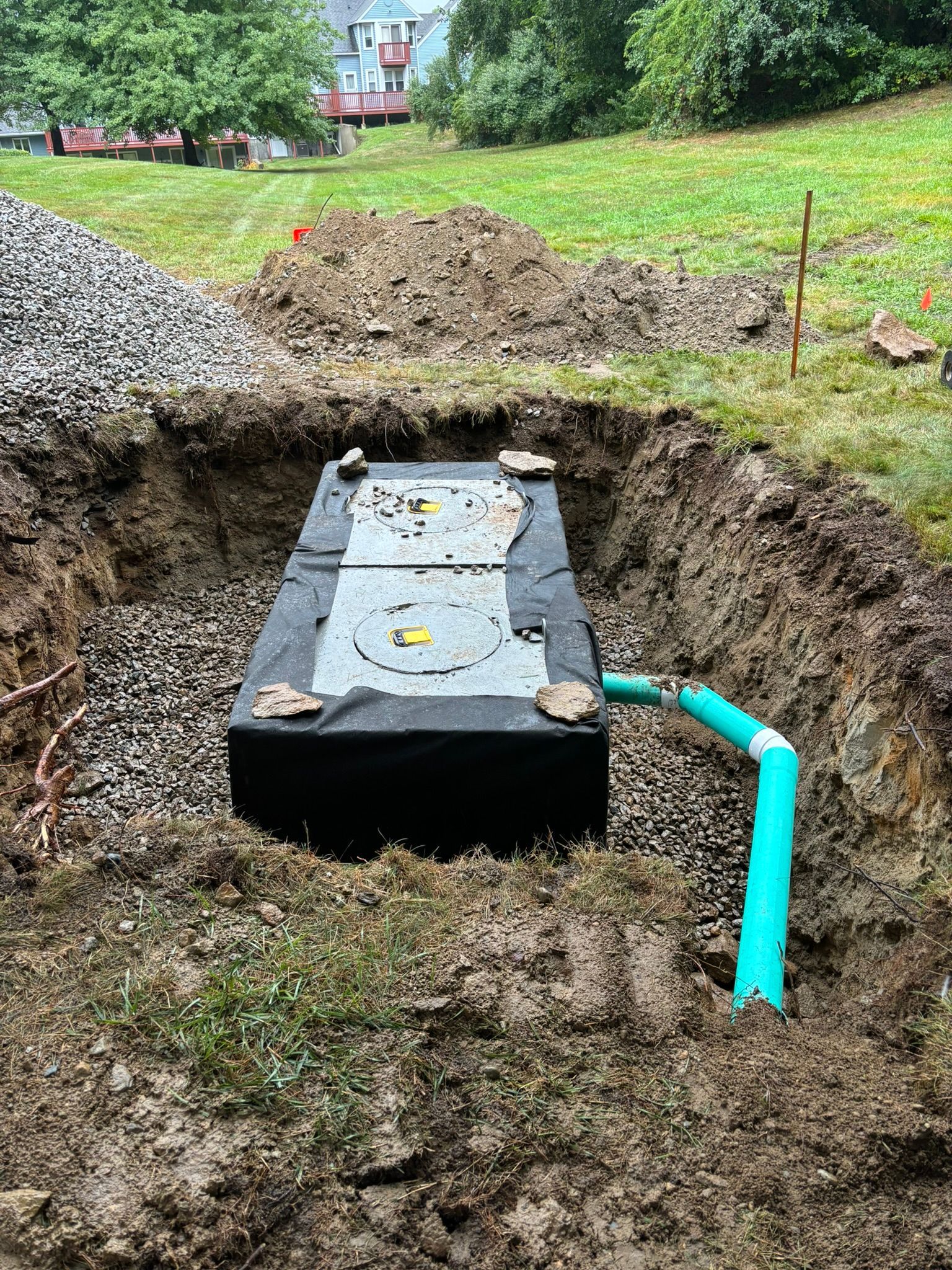 A septic tank is being installed in a hole in the ground.