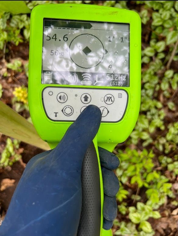 A person is holding a green device in their hand.