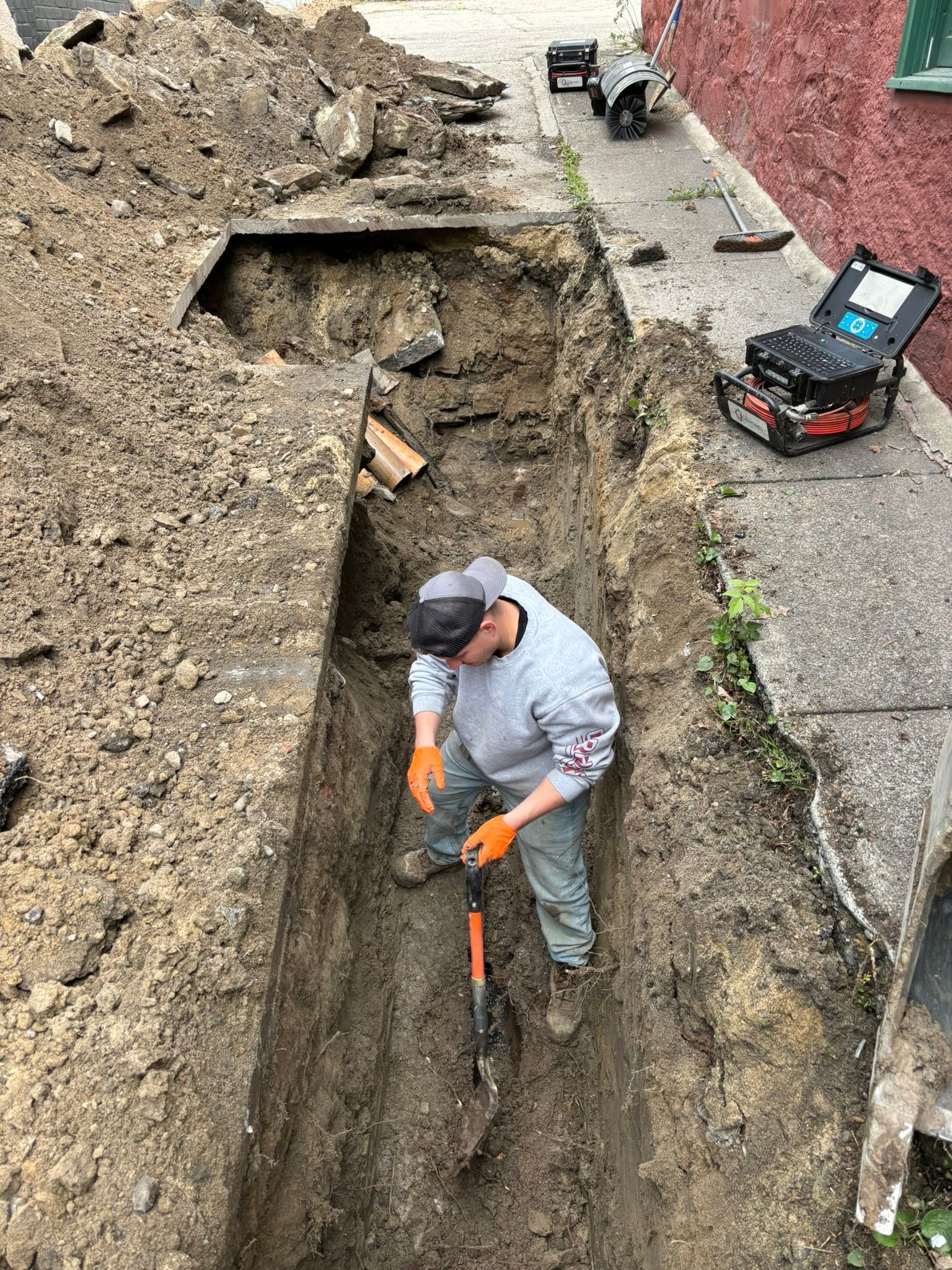 A man is digging a hole in the ground with a shovel.